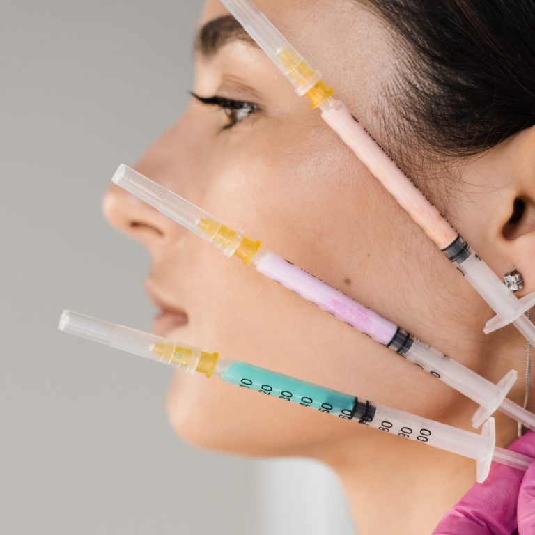 Girl with vitamin cocktail syringes for injections. Mesotherapy injections of vitamins, enzymes, hormones, and plant extracts to rejuvenate and tighten skin and remove excess fat