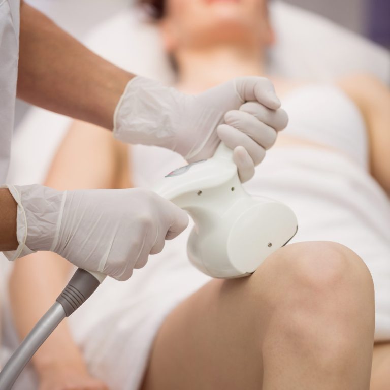 Woman getting anticellulite and anti fat therapy in clinic