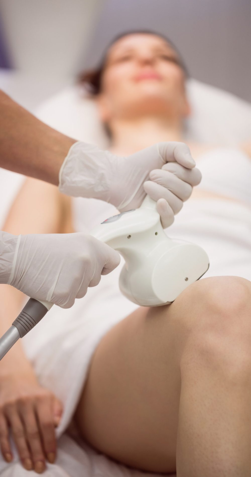 Woman getting anticellulite and anti fat therapy in clinic